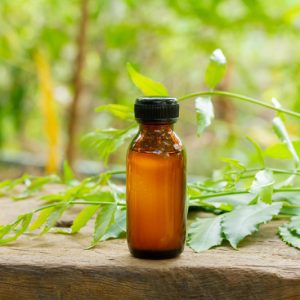 Neem,Oil,In,Bottle,And,Fresh,Neem,Leaf,On,Wooden